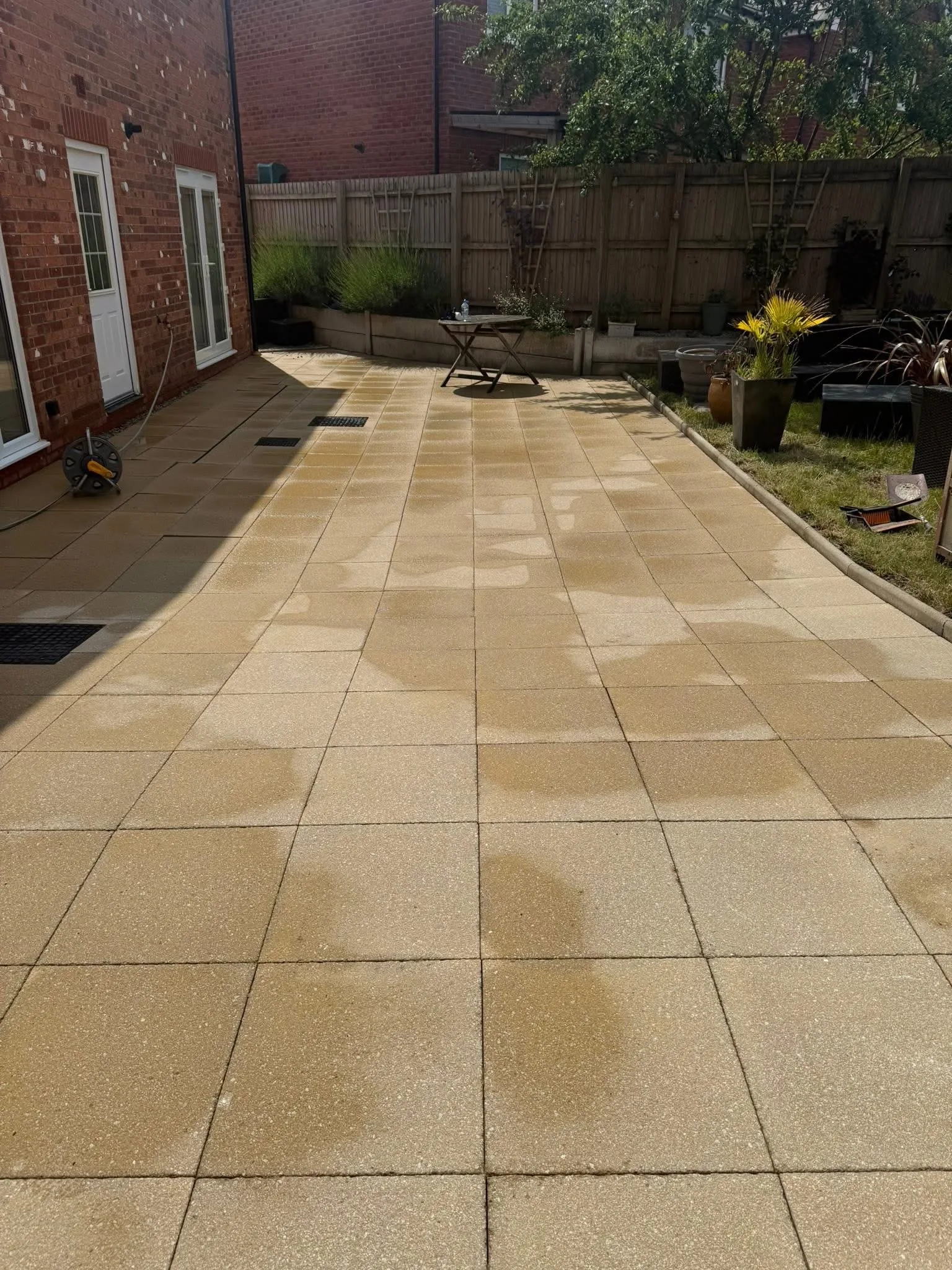 Freshly cleaned modern porcelain patio beside a residential property