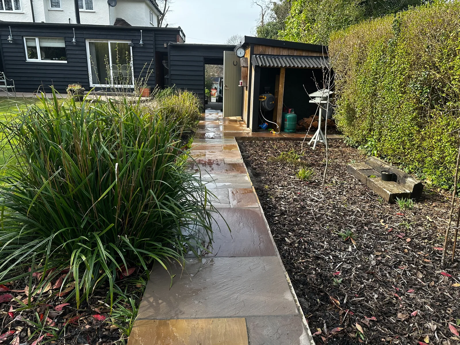 Cleaned natural stone pathway and patio through a landscaped garden