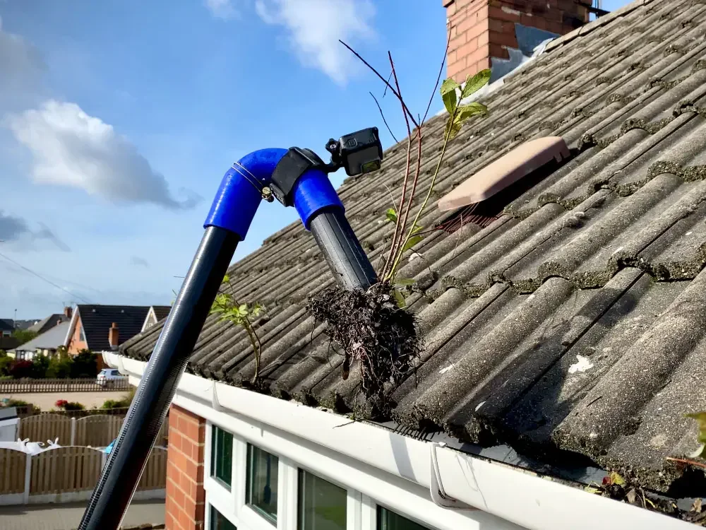 Professional gutter vacuum clearing compacted debris from gutters in Holmes Chapel