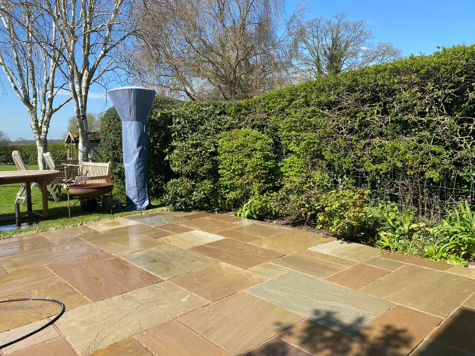Professionally cleaned Indian sandstone patio with outdoor seating