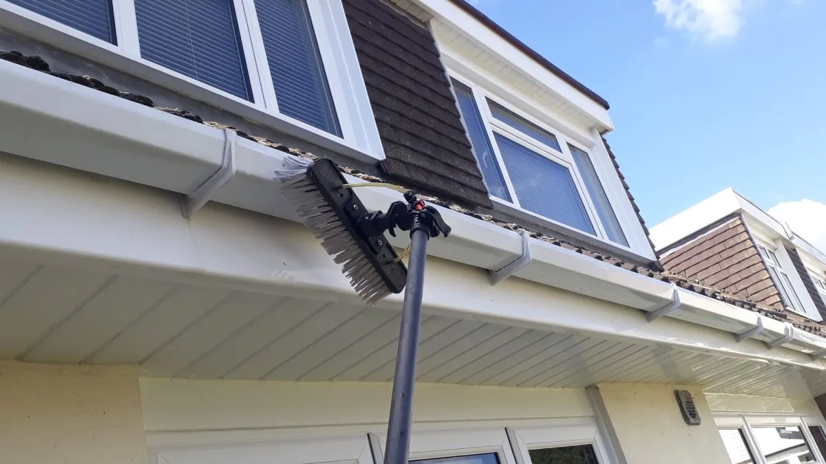 Brush cleaning white guttering and fascias - soffit and fascia cleaning in Macclesfield