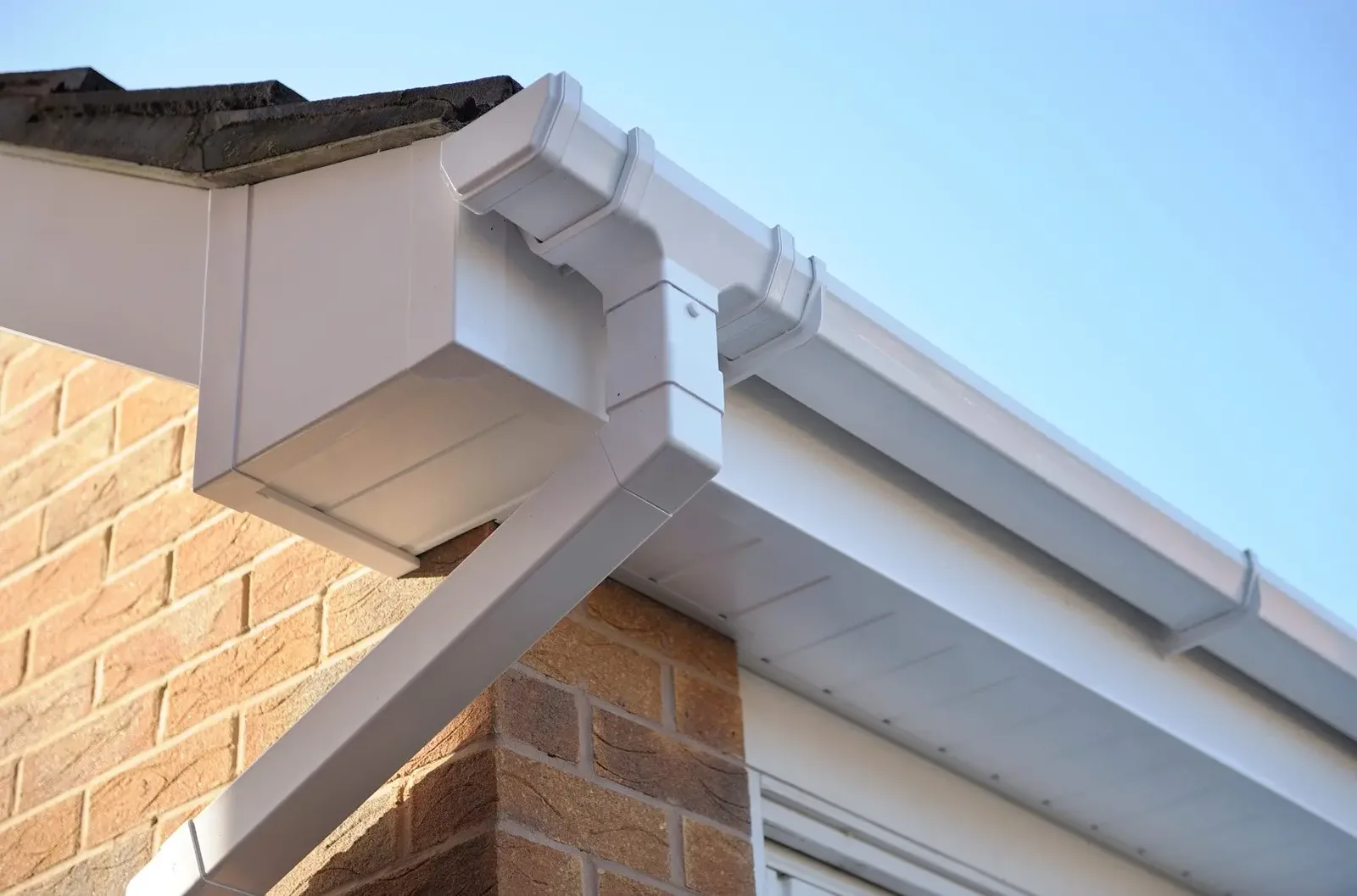 Finished white fascia corner and downpipe - soffit and fascia cleaning in Macclesfield